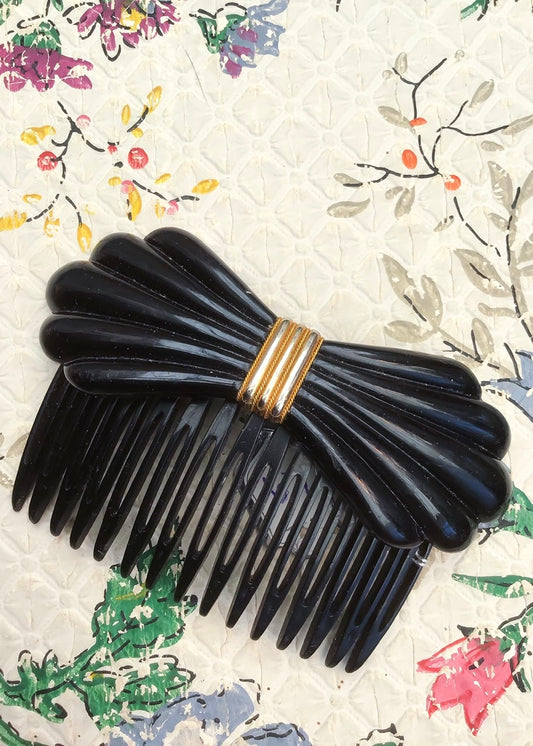 Vintage black plastic bow shaped hair comb with wrapped wire at the centre