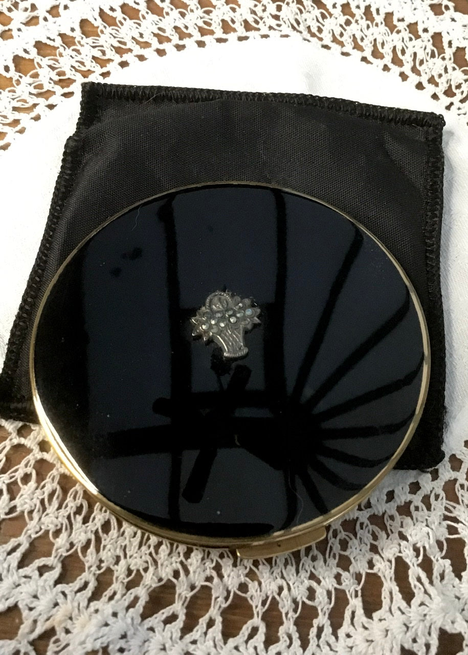 beautiful polished black powder compact case by Stratton with a centred marcasite flower basket  decoration. Fantastic vintage  gift idea