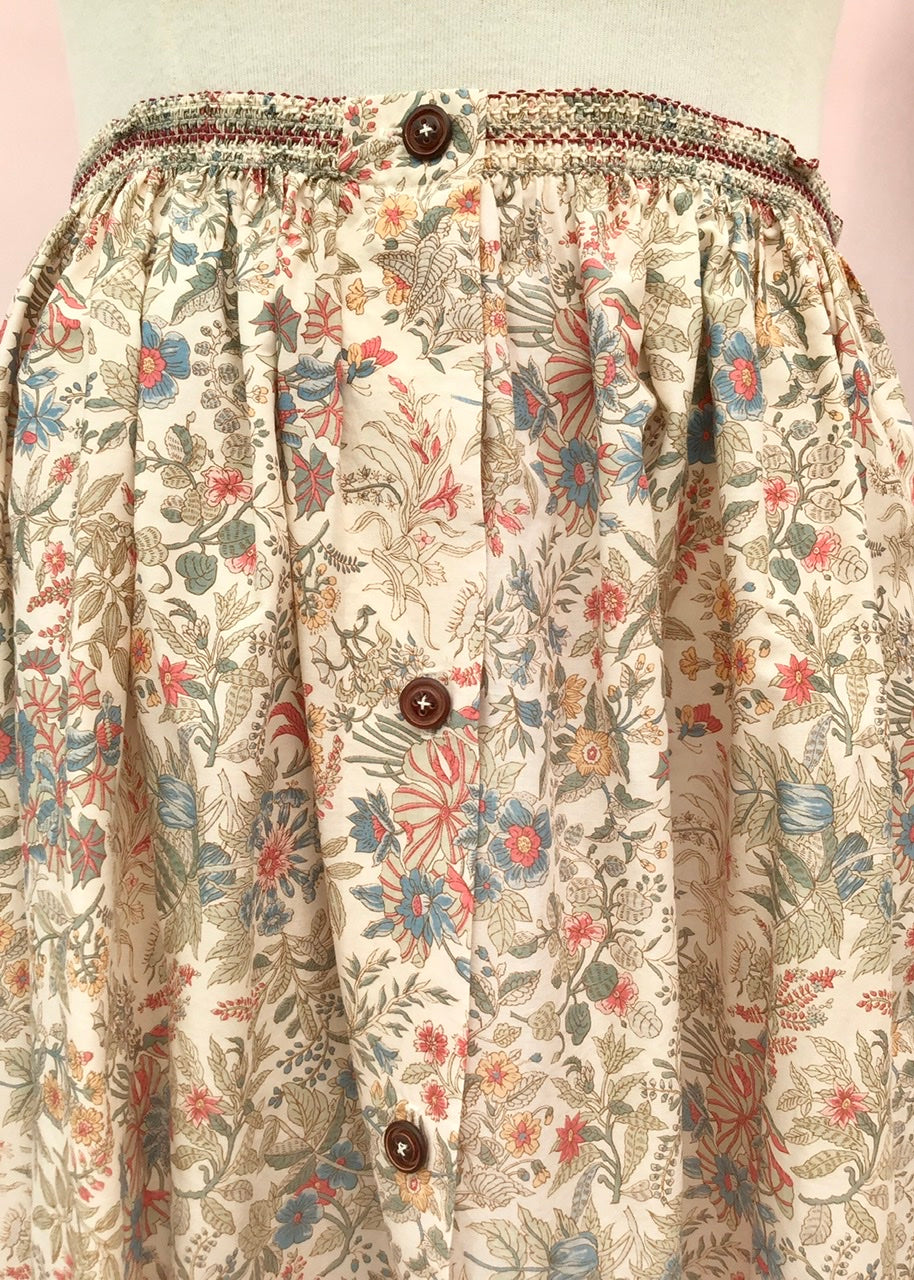 Vintage 70s Liberty print cotton skirt with elastic waist and buttons down the front, beige pastel floral pattern.